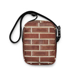 Brick crossbody bag, flat on white, full red brick wall print facing forward
