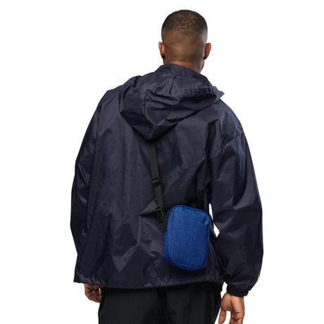 Denim crossbody bag, hanging front view with the strap extended