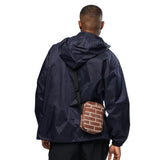 Brick crossbody bag, hanging front view with the strap extended