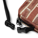 Close-up of the Brick crossbody bag strap clasp and adjustable webbing